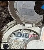 Compteur d eau chez un client en Gironde vue de face avec un petit peu de terre par dessus