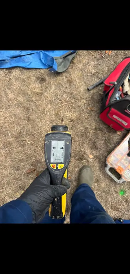 Technicien utilisant une caméra thermique à bout de bras vers le sol extérieur pour localiser une fuite d'eau enterrée en Gironde.